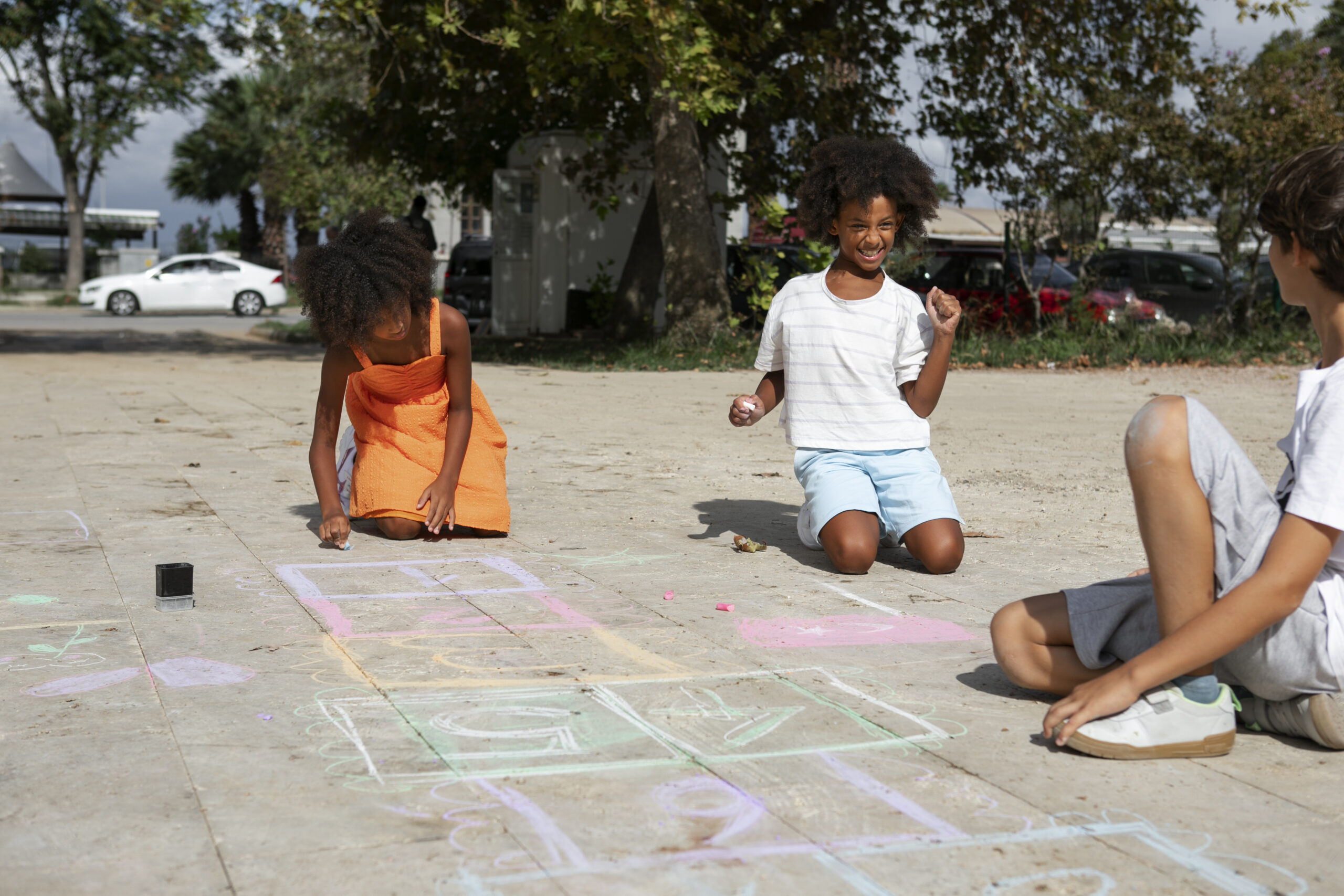 kids drawing pavement full shot